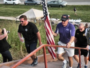 Collinsville Mayor John Miller carries a flag up the steps of Monks Mound / Photo by Roger Starkey