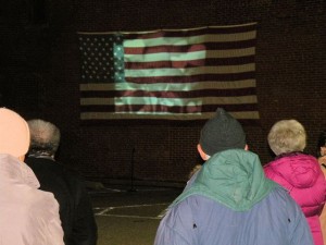 A crowd gathers to watch Martin Luther King Jr.'s '"I Have a Dream" speech projected onto a wall at the city parking lot at Seminary and Main streets / Photo by Roger Starkey