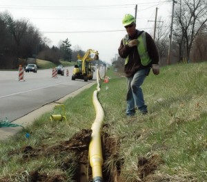 Ameren Illinois gas construction worker Brian Keller radios Pete Deconcini, not pictured, to slowly bury a new six-inch natural gas line underground along Illinois Route 159 near Stonewolf Golf Course in Caseyville.