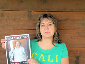 Robin Burton holds a picture of her missing mother, Cloudia Leslie Wells / Photo by Roger Starkey